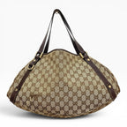 Túi đeo vai The Vintage Mansion Gucci GG canvas họa tiết monogram với chi tiết da nâu và phần cứng kim loại sang trọng.
